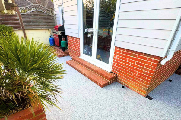 Garden room surrounded by light grey resin-bound surfacing